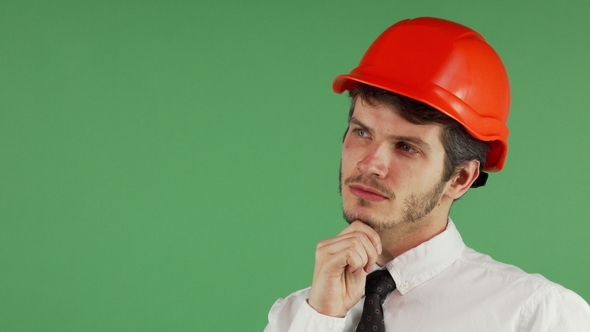 Handsome Male Constructionist in a Hardhat Looking Away Thoughtfully