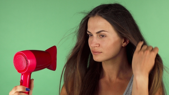 Young Woman Blow Drying Her Hair on Chromakey Background