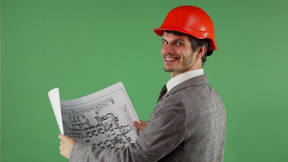 Handsome Bearded Engineer Smiling To the Camera While Examining Blueprints