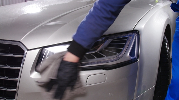 Car Detailing Concept. Man Holds the Microfiber in Hand and Polishes the Car