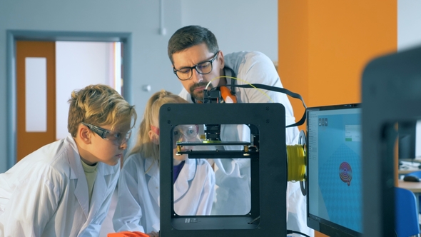Teacher Explains Children 3D Printing Process in a Laboratory