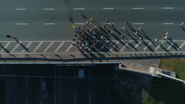 Aerial Drone Fooage. Following Marathon Running On Road Bridge. Top View