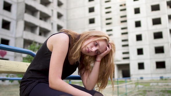 Nervous Girl Is Sitting Near High Building