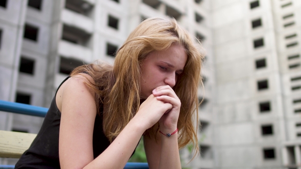 Nervous Girl Is Sitting Near High Building