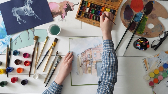 Female Artist Drawing a Picture of a Town