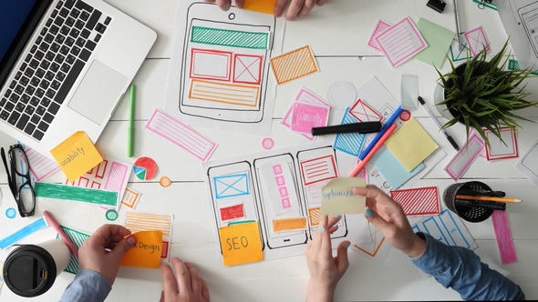 UX Designers Putting Post It Notes on App Layout