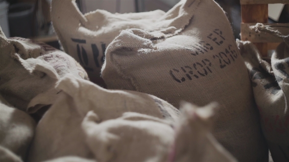 Heap of Canvas Bags Filled with Freshly Roasted Coffee Grains and Arranged Together in Store