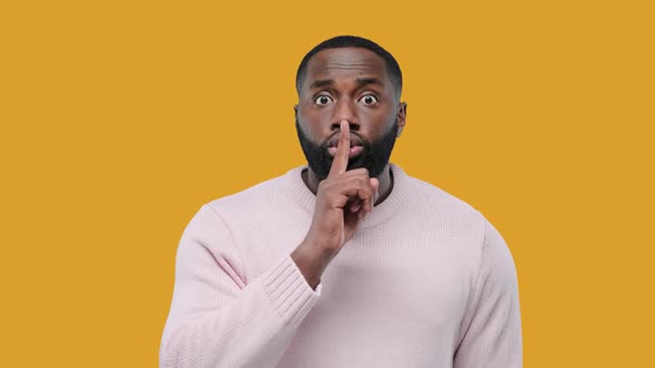 African American Man Showing Hush Gesture Isolated on Yellow Background, Keeping Finger on Lips