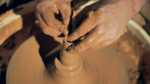 A Potter Touches Clay on a Wheel