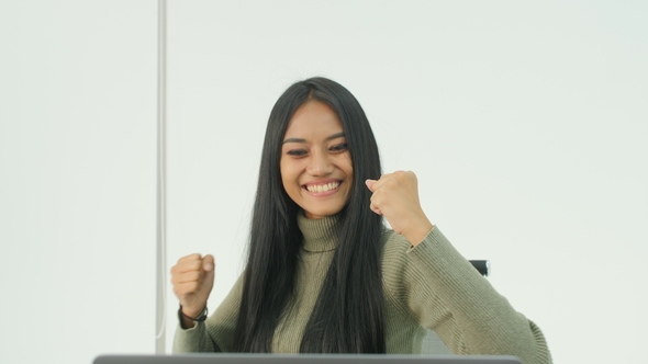 Portrait of an Excited Young Asian Woman Rejoicing Success