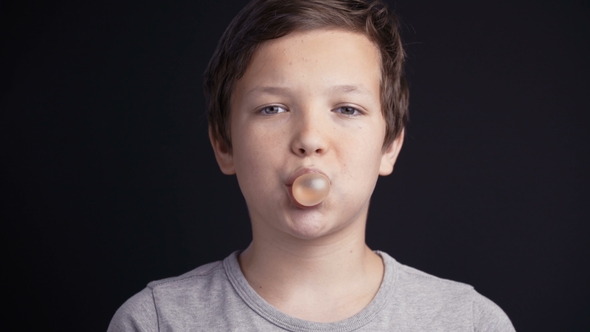 Footage Boy Make Bubble with Chew on Dark Background