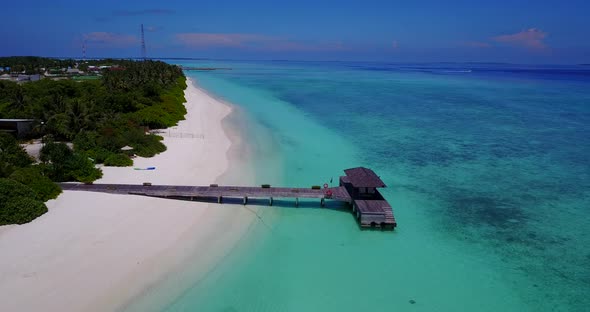 Beautiful flying abstract shot of a sandy white paradise beach and aqua blue ocean background in col