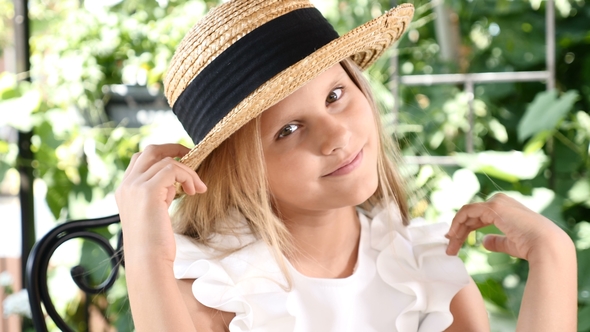 Portrait of Blond Attractive Girl Smiling, Touching Her Hair with a Straw Hat On. Lifestyle. Happy
