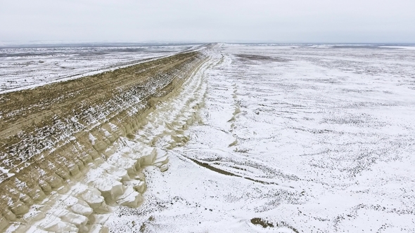 Edge of a Sandy Cliff of the Snow-covered Desert in Winter. Western Kazakhstan, Mangyshlak Peninsula