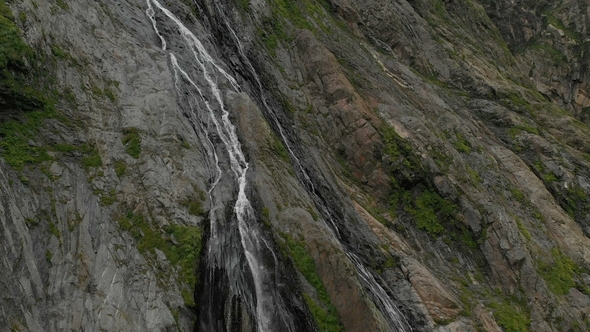 Tracking and Top Shot Air Shot From a Stream of Water Splashing Waterfall on a Rock Wall in the