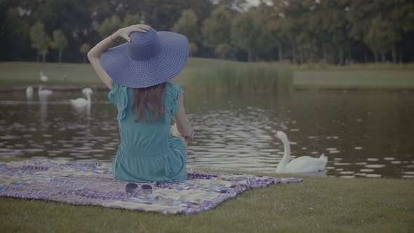 Stylish Woman in Sun Hat Enjoying Nature in Park