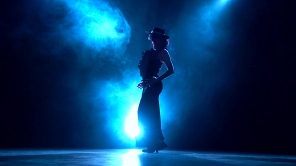 Girl in an Incendiary Dance of Argentine Flamenco . Llight From Behind. Smoke Background. Silhouette