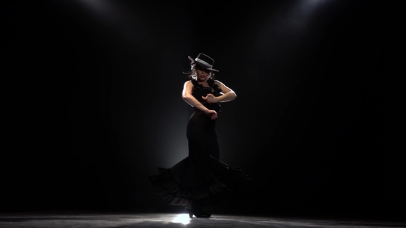 Flamenco. Girl Is Dancing a Spanish Incendiary Dance. Black Background. Llight From Behind