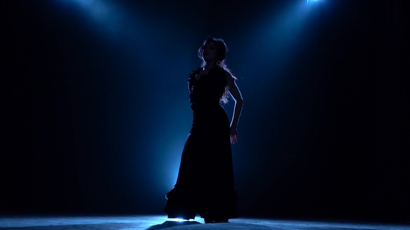 Dancer Performs Professional Flamenco Movements. Llight From Behind. Smoke Background. Silhouette