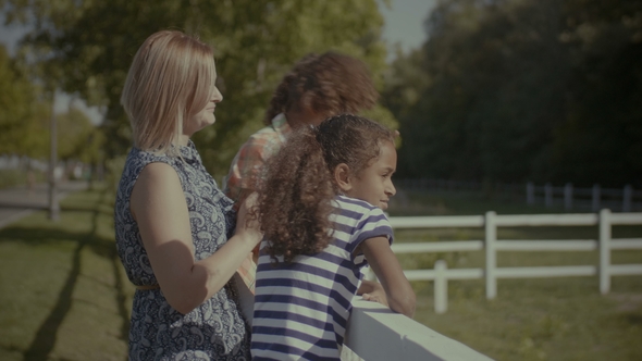 Joyful Diverse Family Leaning on Fence Outdoors