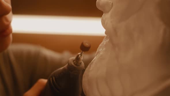 Craftswoman Polishing Plaster Bust in Workshop