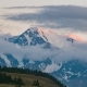 The Sun Sets and Clouds Cover the Snow Peak. Landscape Sunset in the Mountains - VideoHive Item for Sale