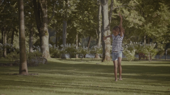 Active Little Girl Doing Cartwheel on Green Grass alt