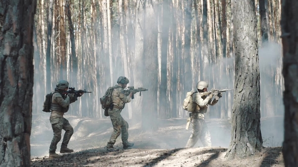 Squad of Three Fully Equipped Soldiers on a Military Mission in Forest