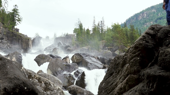 The Traveler Scrambles Along the Cascading Waterfall