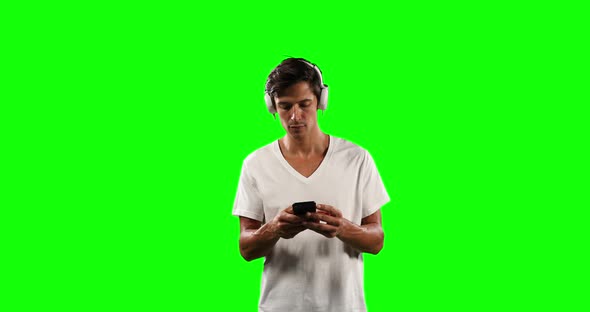 Front view of a Caucasian man listening music with green screen