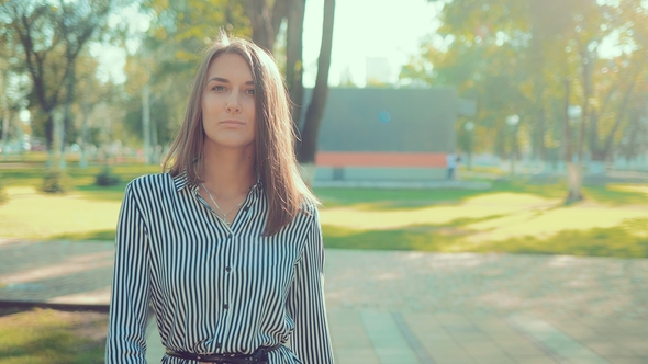 Portrait of a Young Beautiful Girl Walking Through the Park at a Rapid Pace