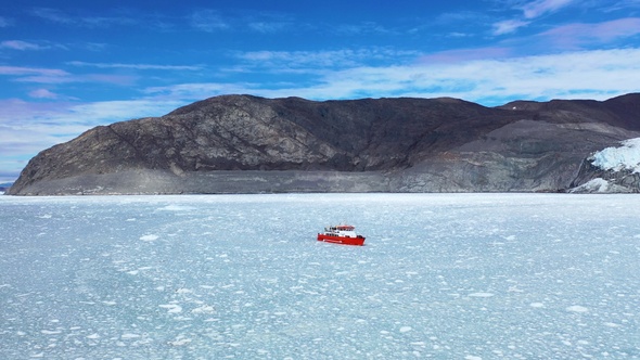 Environment. Cruise ship surrounded by icebergs and ice. Aerial view. Arctica. Greenland, Disco bay.