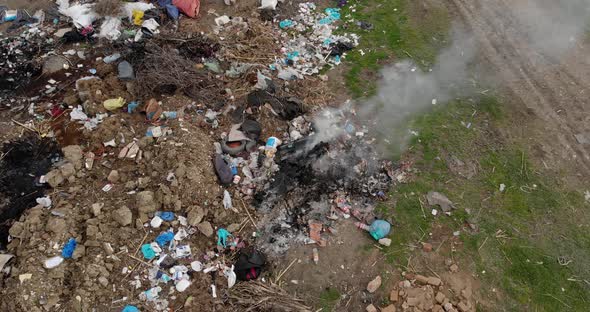 Pile of trash on the side of the road burning , close up