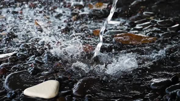 Stream of Water Pours on the Stones