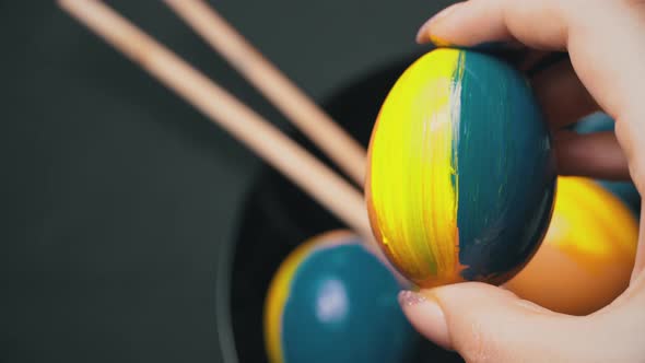 Girl Paints Easter Eggs in YellowBlue Color