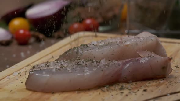 Professional Chef Sprinkles Fish Steak with Pepper