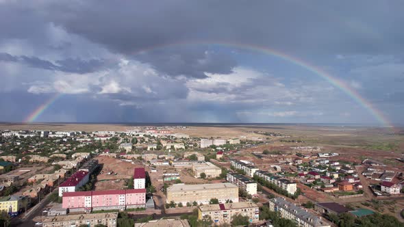 Bright Rainbow and Rain Over the City Near Lake