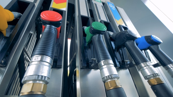 One Man Uses a Fuelling Equipment at a Gas Station, Taking a Nozzle