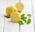 Ripe lemons and a mint branch on a white wooden table. - PhotoDune Item for Sale