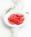 Peeled grapefruit slices and rosemary sprigs in a white plate on - PhotoDune Item for Sale
