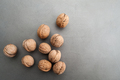 Uncleaned walnuts on a gray textured stone table with a free spa - PhotoDune Item for Sale