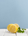 Half a ripe lemon and a mint branch on a white wooden table on a - PhotoDune Item for Sale