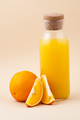 Fresh orange juice in a glass bottle and orange on a light beige - PhotoDune Item for Sale