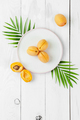 Ripe apricots on a round plate on a white board table. - PhotoDune Item for Sale