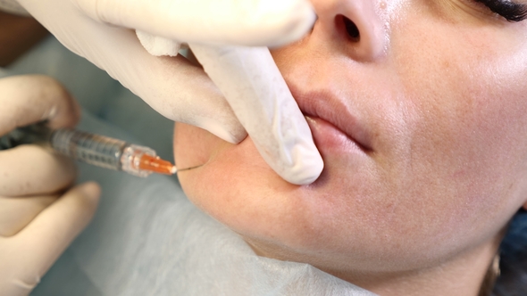 Woman in Beauty Centre and Beautician with Syringe in Hands. Doctor Making Anti-aging Injections