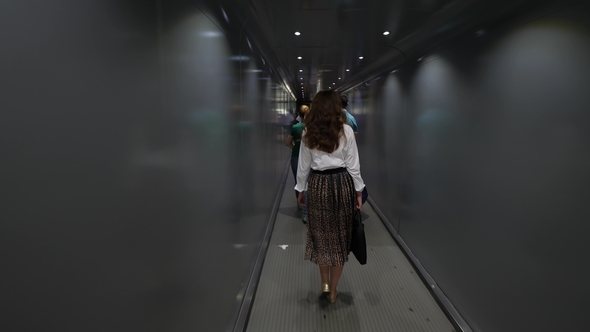 Pensive Girl Looks Out the Jetway Before Getting on Airplane