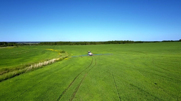 Flycam Follows Tractor Trace on Vast Green Field