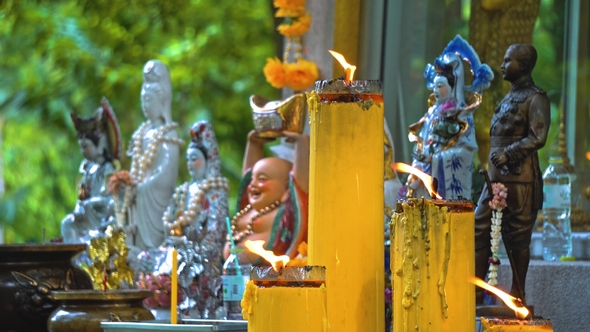 Temple Buddha Under the Trees. Buddhism in Asia. Candles and Flowers. Place of Religious