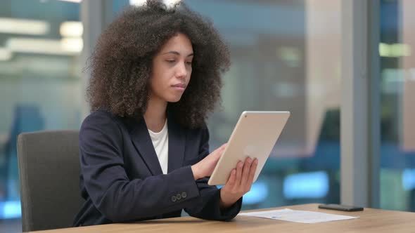 African Businesswoman Celebrating on Tablet at Work