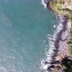 Aerial view of the ocean and cliffs. A car appears from the tunnel. - VideoHive Item for Sale
